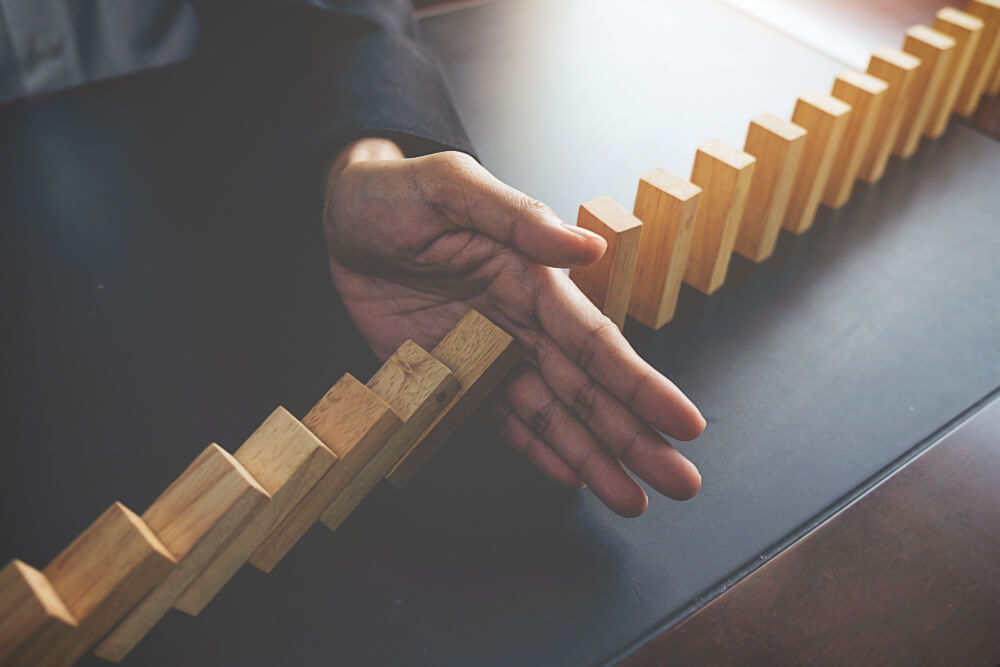 problem-solving-close-up-view-hand-business-woman-stopping-falling-blocks-table-concept-about-taking-responsibility(1)